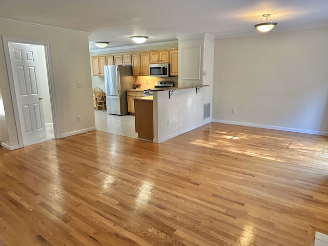 kitchen featuring visible vents, light wood finished floors, stainless steel appliances, crown molding, and open floor plan