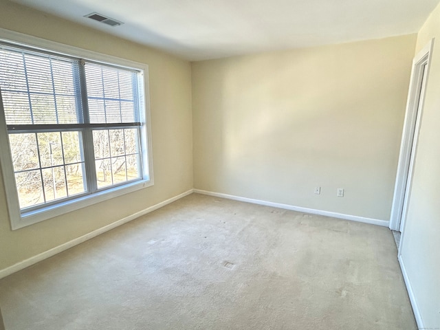 unfurnished room featuring visible vents, baseboards, and light carpet