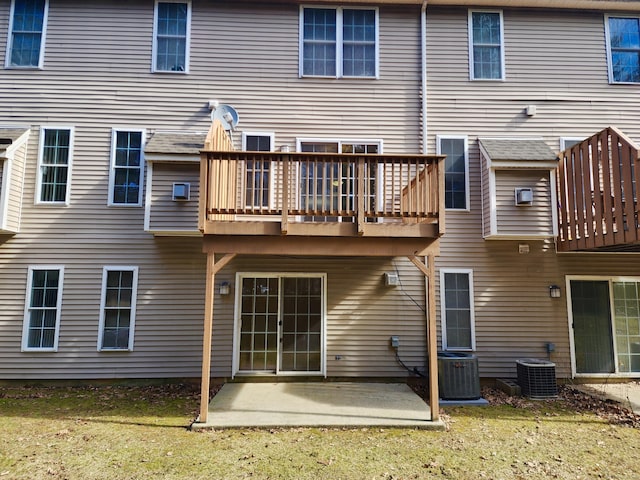 back of property with a deck, cooling unit, a patio area, and a yard