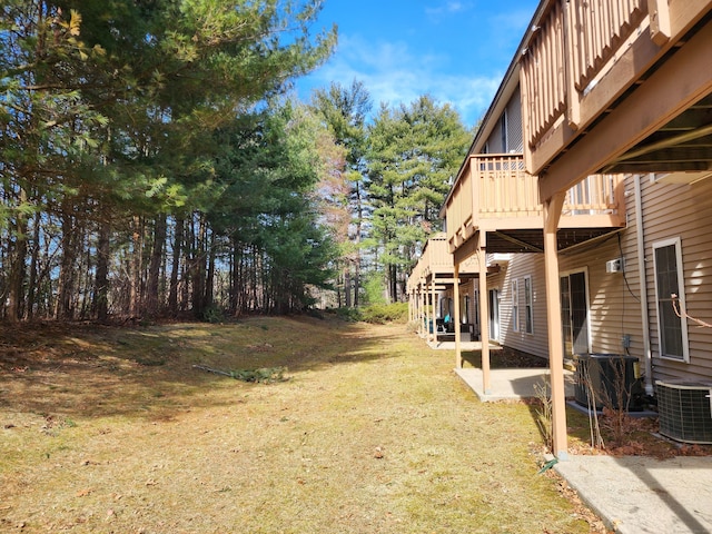 view of yard featuring a patio area, cooling unit, and a wooden deck