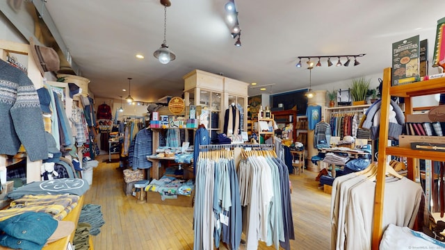 miscellaneous room with hardwood / wood-style flooring and track lighting