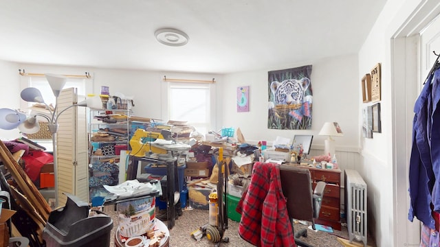 home office featuring carpet flooring, a wainscoted wall, and radiator heating unit