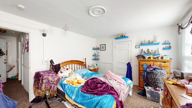 bedroom with wainscoting and carpet