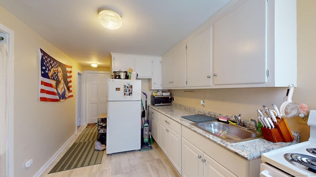 kitchen with light countertops, white appliances, a sink, and white cabinets