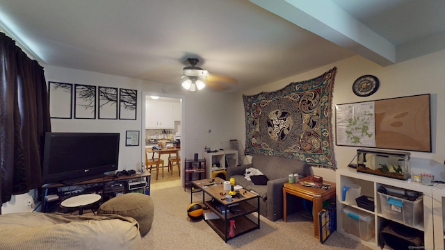 living room featuring carpet floors, beamed ceiling, and a ceiling fan