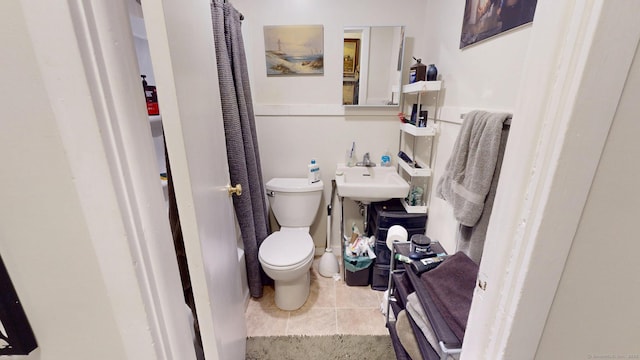 bathroom with tile patterned flooring, a sink, and toilet