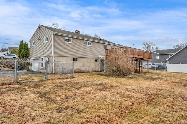 back of house featuring a yard, a chimney, a gate, fence, and a deck