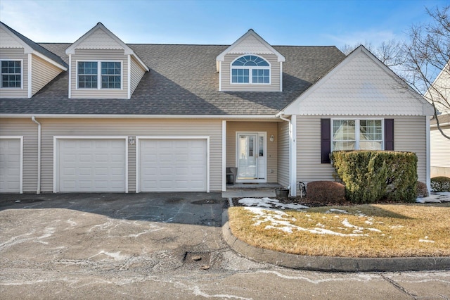 view of front of house featuring aphalt driveway, roof with shingles, and a garage