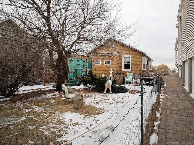 snow covered property with fence