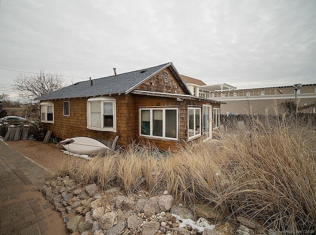 back of property with a shingled roof