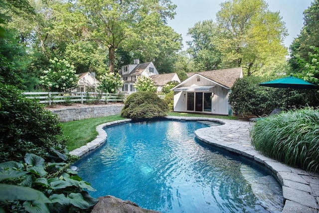 pool with a patio area, an outdoor structure, an exterior structure, and fence