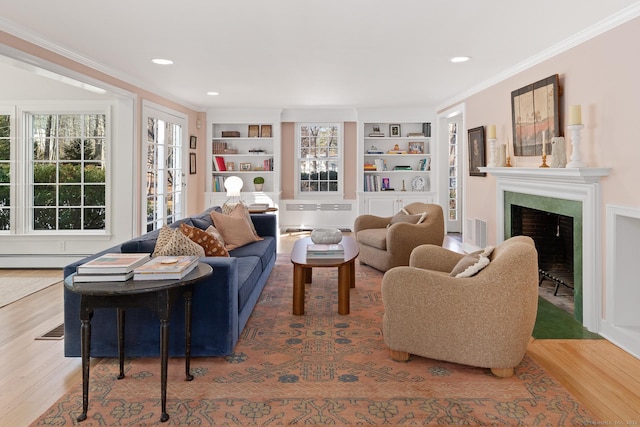 living room with a wealth of natural light, radiator, visible vents, and wood finished floors