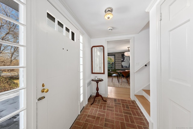 entryway featuring brick floor and baseboards