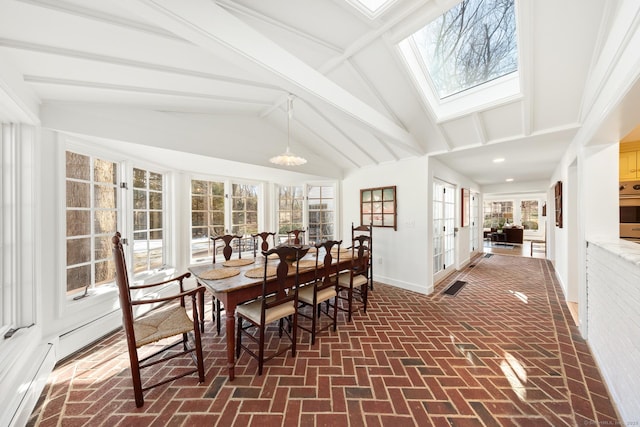 sunroom / solarium featuring lofted ceiling with skylight and french doors