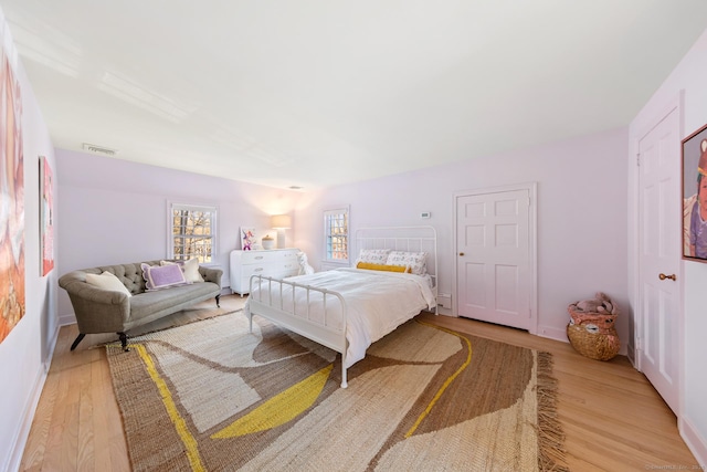 bedroom with light wood-type flooring and visible vents