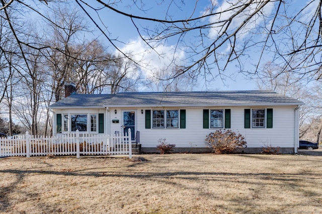 ranch-style home with a front yard, a fenced front yard, and a chimney