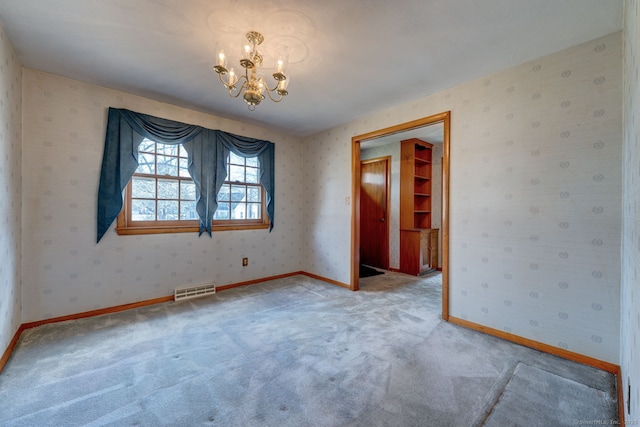 unfurnished room featuring baseboards, visible vents, carpet floors, wallpapered walls, and a chandelier