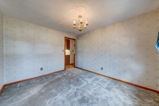 empty room featuring baseboards, carpet floors, an inviting chandelier, and wallpapered walls