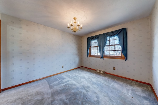 carpeted empty room featuring visible vents, baseboards, an inviting chandelier, and wallpapered walls