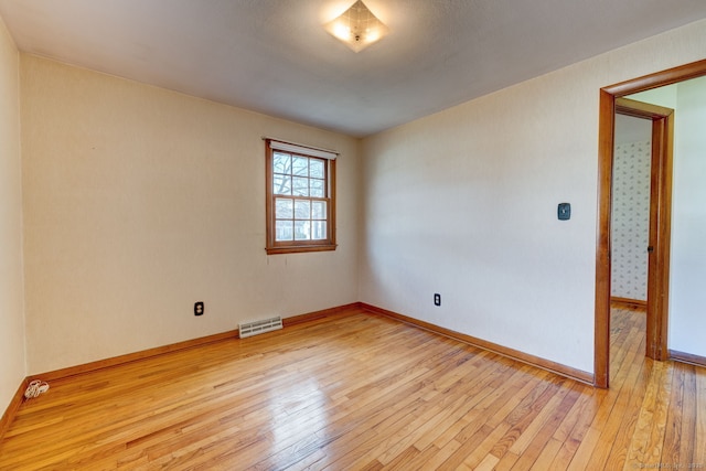 empty room with visible vents, baseboards, and light wood finished floors