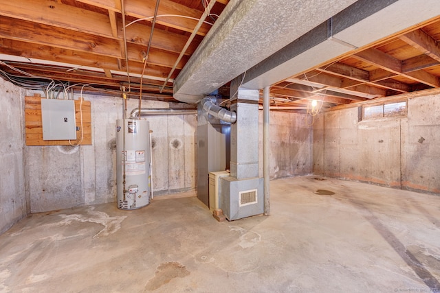 unfinished below grade area featuring gas water heater, heating unit, and electric panel