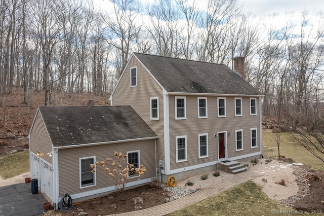 view of front of home featuring a garage and a chimney