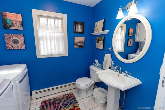 bathroom featuring toilet, a baseboard heating unit, separate washer and dryer, and tile patterned floors