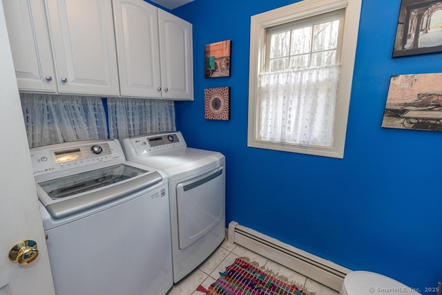 laundry area with a baseboard heating unit, plenty of natural light, washing machine and clothes dryer, and light tile patterned floors