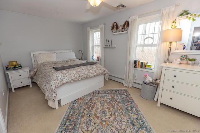 bedroom with ceiling fan, multiple windows, a baseboard radiator, and visible vents