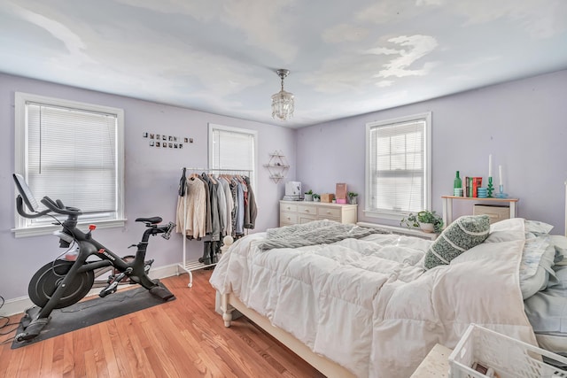 bedroom featuring a closet, light wood-style flooring, and baseboards