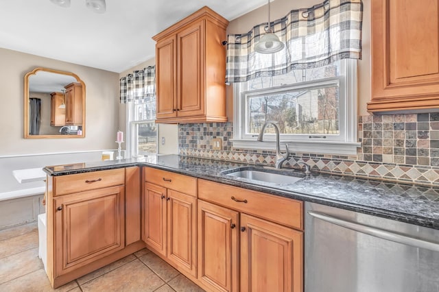 kitchen featuring plenty of natural light, a sink, stainless steel dishwasher, and light tile patterned floors