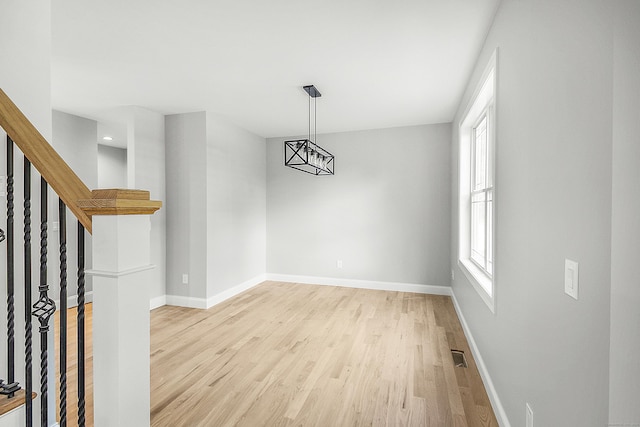 unfurnished dining area featuring stairs, wood finished floors, visible vents, and baseboards