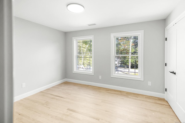 unfurnished room with light wood-style floors, baseboards, and visible vents