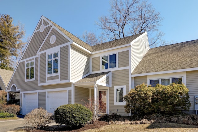 view of front of property featuring an attached garage and a shingled roof