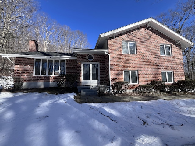 tri-level home with brick siding and a chimney