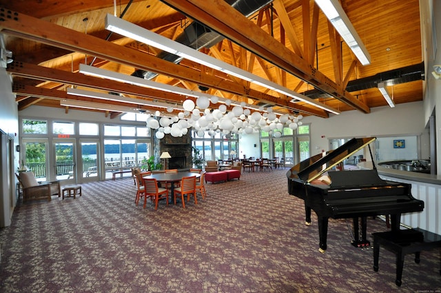 carpeted dining space featuring beam ceiling, wood ceiling, a fireplace, and high vaulted ceiling