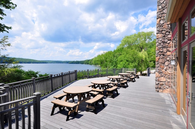 deck featuring outdoor dining area and a water view