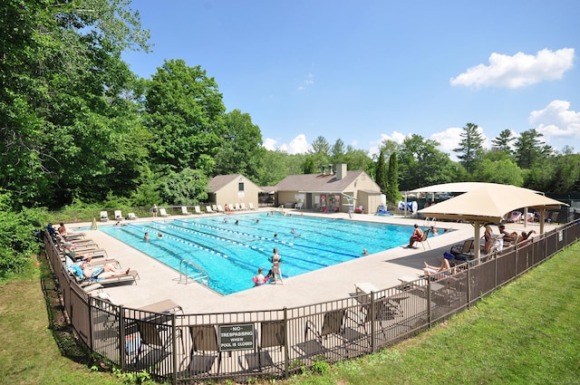 pool with a patio and fence