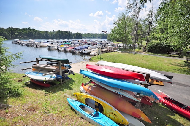 view of dock featuring a lawn and a water view