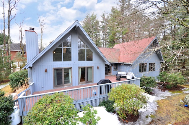 back of house with a deck and a chimney