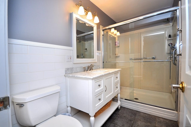 full bath with vanity, tile walls, a shower stall, and toilet