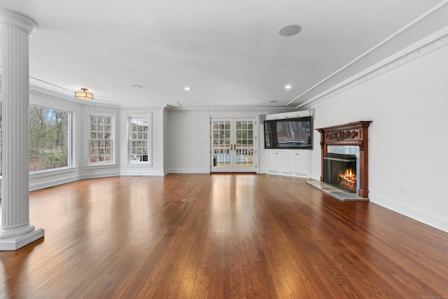 unfurnished living room with wood finished floors, ornate columns, and a premium fireplace