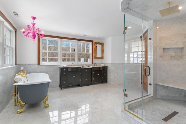 bathroom with double vanity, visible vents, tile walls, and a shower stall