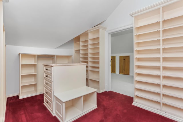 walk in closet featuring lofted ceiling and dark colored carpet