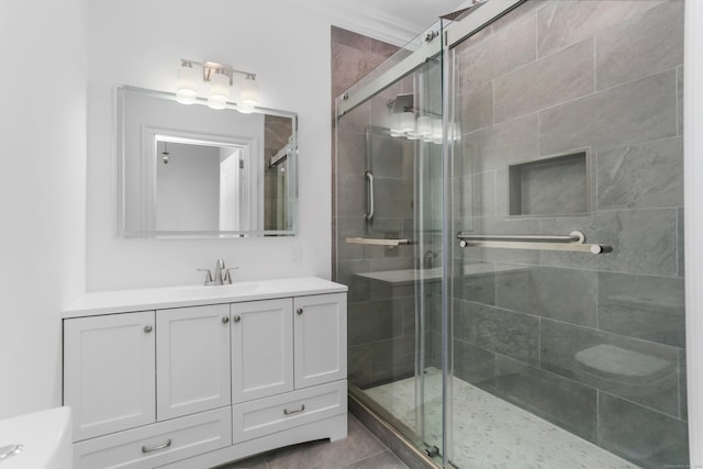 full bath with tile patterned flooring, a stall shower, and vanity