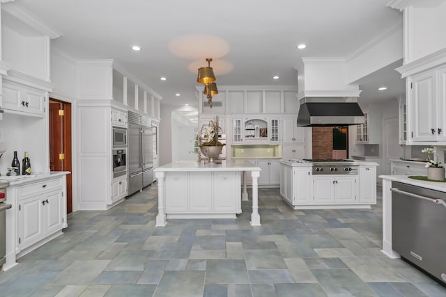 kitchen with built in appliances, white cabinetry, a center island, and light countertops