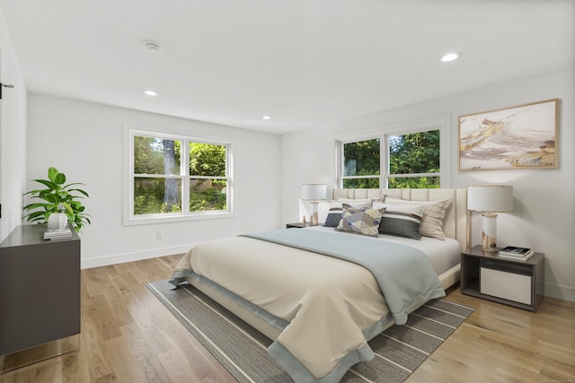 bedroom featuring light wood finished floors, multiple windows, baseboards, and recessed lighting