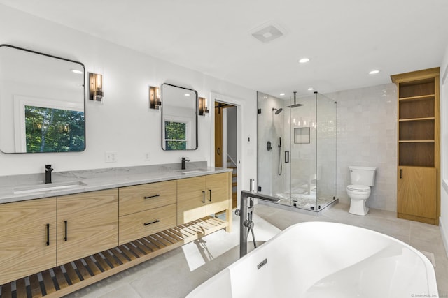 full bathroom with a stall shower, a sink, a freestanding bath, and double vanity