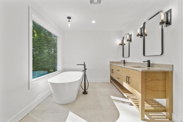 bathroom featuring a freestanding tub, a sink, baseboards, tile patterned floors, and double vanity