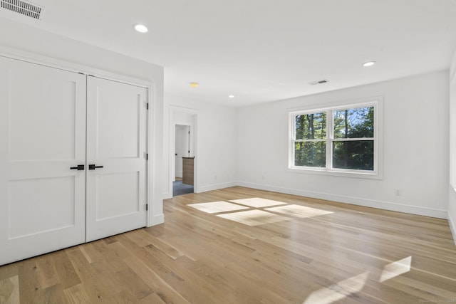 spare room with light wood-style floors, baseboards, visible vents, and recessed lighting